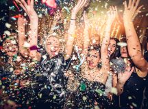 Confetti falling over a smiling group of people on a dance floor of a nightclub